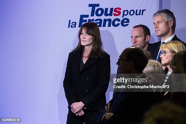 Former French President and presidential candidate hopeful Nicolas Sarkozy's wife Carla Bruni-Sarkozy looks on as he speaks after the first round of...