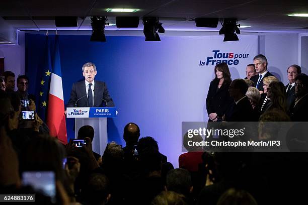 Former French President and presidential candidate hopeful Nicolas Sarkozy speaks, as his wife Carla Bruni-Sarkozy, looks on after the first round of...