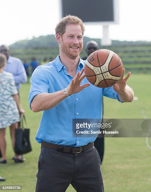 Prince Harry plays basketball as he attends a Youth Sports Festival at the Sir Vivian Richards Stadium on the second day of an official visit on...
