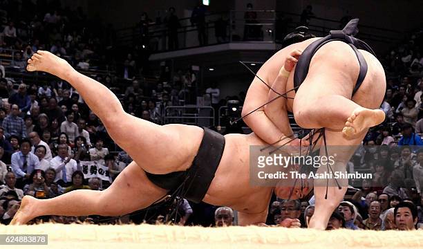 Ozeki Kisenosato throws ozeki Goeido to win during day nine of the Grand Sumo Kyushu Tournament at Fukuoka Convention Center on November 21, 2016 in...