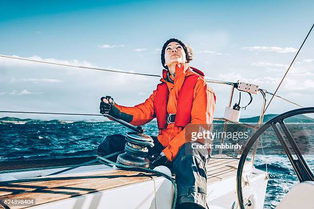 glückliche frau segeln während der regatta - segeln stock-fotos und bilder
