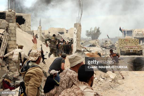 Forces loyal to Libya's Government of National Accord hold a position amid the rubble of destroyed buildings in Sirte's Al-Giza Al-Bahriya district...