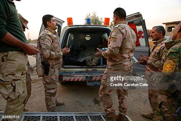Captain Osama Fuad Rauf and some of the other medical personnel say a prayer as the bodies of two soldiers after the bodies of two soldiers are...