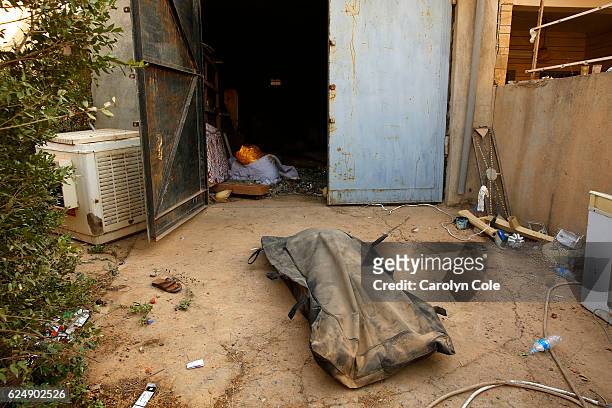 The body of a dead soldiers waits to be moved into the refrigerated truck, which serves as a field morgue at the Iraqi Army's 9th Armored Division...