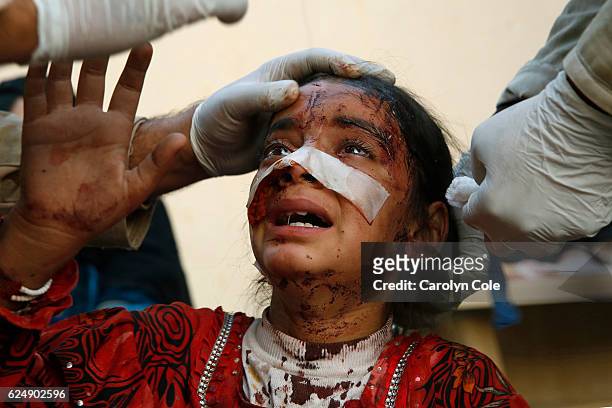 Menar Hassan, age 8, cries as doctors try to stick her wounds caused by a suicide truck bombing. He father died on the scene and had to be left in...