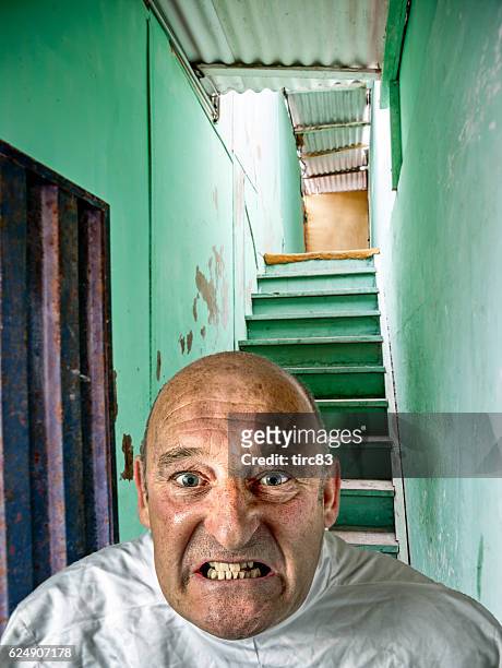 senior bald man in strait jacket restraint - straight jacket stock pictures, royalty-free photos & images