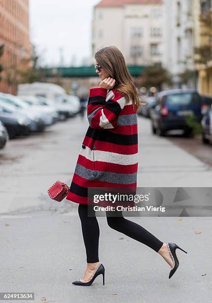 Jennifer Amanda wearing a red striped Gabrie oversized coat from Isabel Marant Etoile, a black rainbow logo sweater from Isabel Marant Etoile, "So...