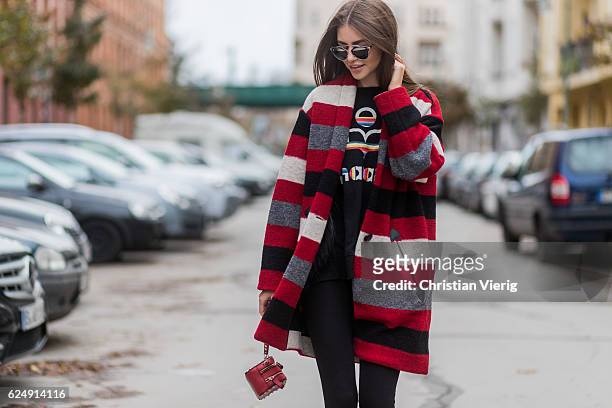 Jennifer Amanda wearing a red striped Gabrie oversized coat from Isabel Marant Etoile, a black rainbow logo sweater from Isabel Marant Etoile, "So...