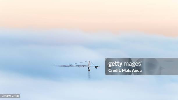 crane in a sea of fog - guindaste maquinaria de construção imagens e fotografias de stock