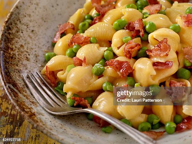 creamy shells and cheese carbonara with peas - conchiglie stockfoto's en -beelden