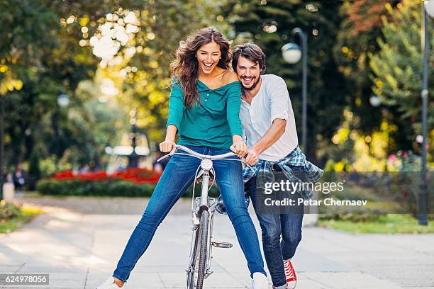 lovely couple with a bike - bicycle and couple stockfoto's en -beelden