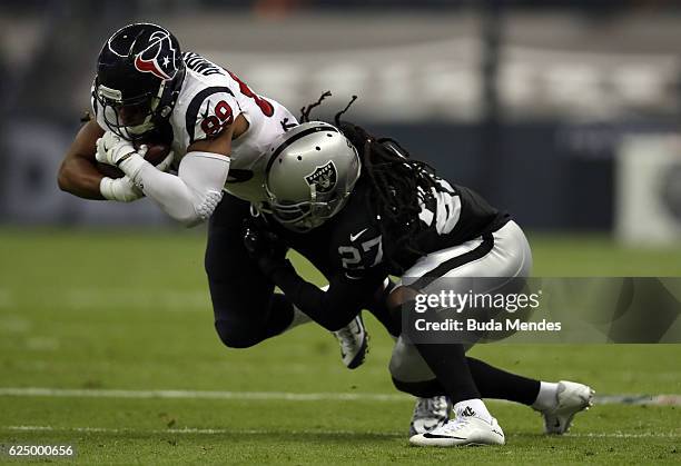 Stephen Anderson of the Houston Texans is tackled by Reggie Nelson of the Oakland Raiders after catching a pass in their game at Estadio Azteca on...