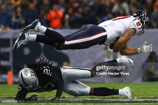 Fiedorowicz of Houston Texans jumps over Reggie Nelson of Oakland Raiders during the NFL football game between Houston Texans and Oakland Raiders at...