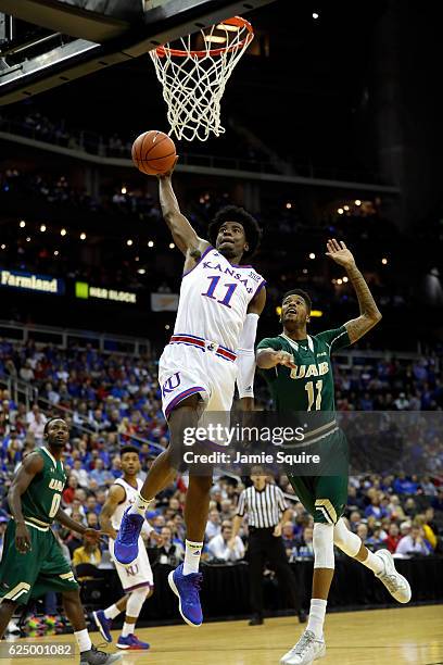 Josh Jackson of the Kansas Jayhawks goes up for a dunk as Dirk Williams of the UAB Blazers defends during the CBE Hall of Fame Classic game at the...