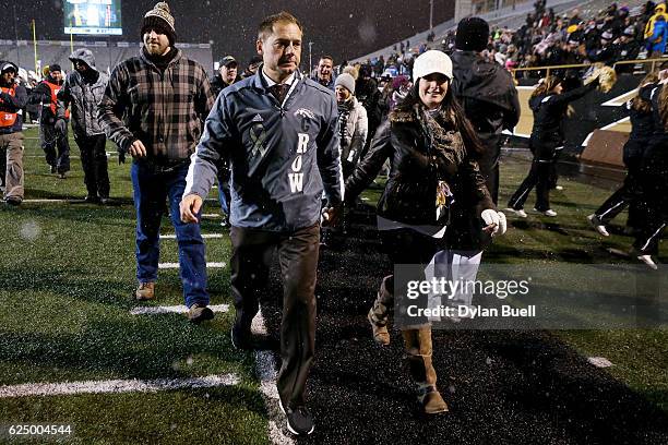 Head coach P.J. Fleck of the Western Michigan Broncos walks off the field with wife Heather Fleck after beating the Buffalo Bulls 38-0 at Waldo Field...