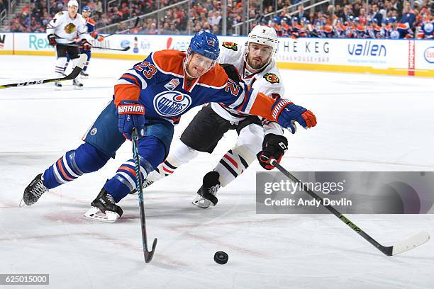 Matt Hendricks of the Edmonton Oilers battles for the puck against Brent Seabrook of the Chicago Blackhawks on November 21, 2016 at Rogers Place in...