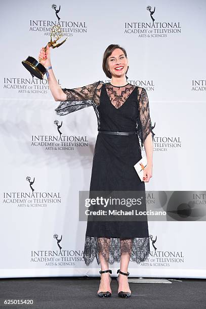 Christiane Paul poses with the "Best Performance by an Actress" award in the press room during the 44th International Emmy Awards at New York Hilton...