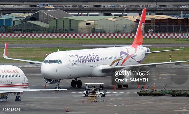 Car drives pass a grounded TransAsia airbus plane at the Sungshan Airport in Taipei on November 22, 2016. Taiwan's TransAsia Airways said it would...