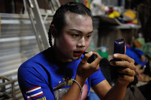 Somros Pholcharoen Thai ladyboy Muay Thai boxer applies a red lipstick before the Muay Thai fight.