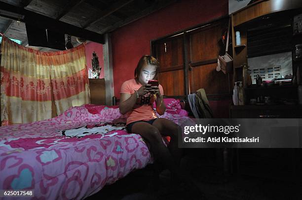 Somros Pholcharoen Thai ladyboy Muay Thai boxer using smarthphone in her bed room.