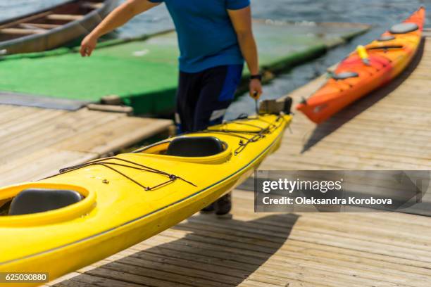 colorful canoes and kayaks by the lake on a sunny day. - fibreglass stock pictures, royalty-free photos & images