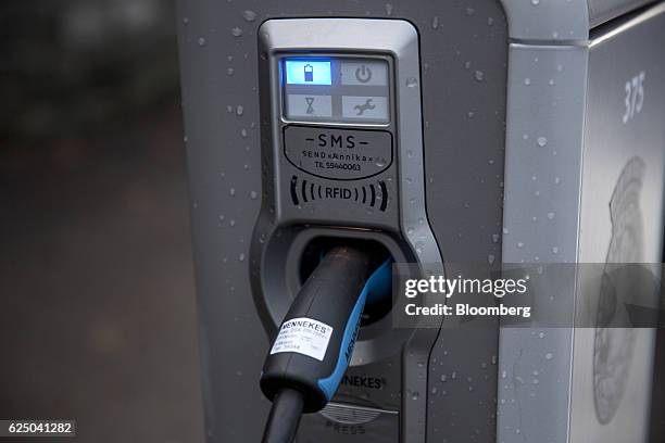Electric vehicle charging plugs sit connected to a charging station at Kongens gate near Akershus festning in Oslo, Norway, on Monday, Nov. 21, 2016....