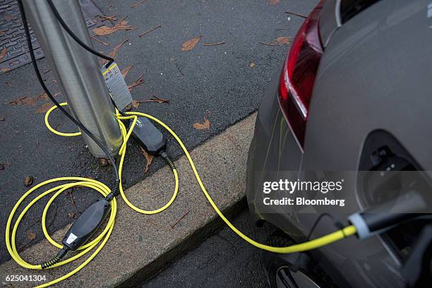An elkectrical plug connects an electric vehicle to a charging station at Kongens gate near Akershus festning in Oslo, Norway, on Monday, Nov. 21,...