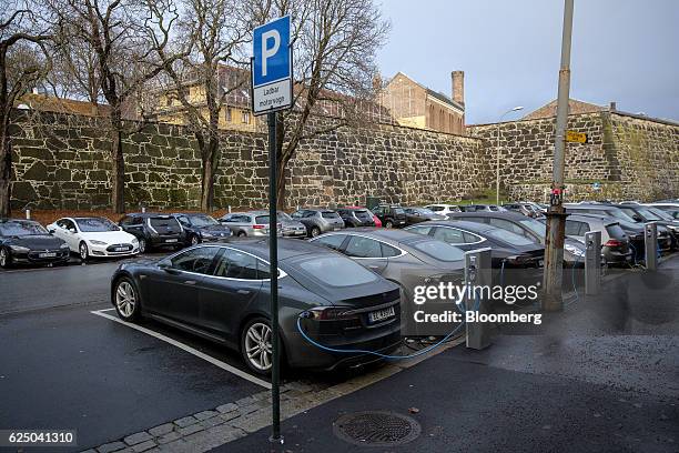Electric vehicles sit parked at charging stations at Kongens gate near Akershus festning in Oslo, Norway, on Monday, Nov. 21, 2016. The International...