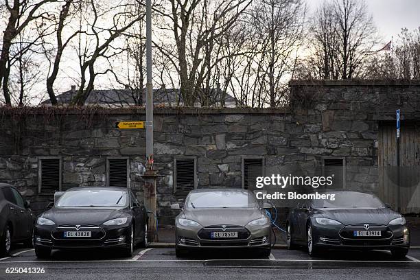 Several Tesla Motors Inc. Model S electric vehicles sit parked at charging stations at Kongens gate near Akershus festning in Oslo, Norway, on...