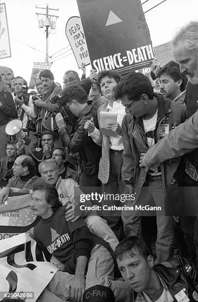 Protesters hold signs, including one with the slogan "Silence Equals Death" at a protest organized by AIDS activist group ACT UP at the headquarters...