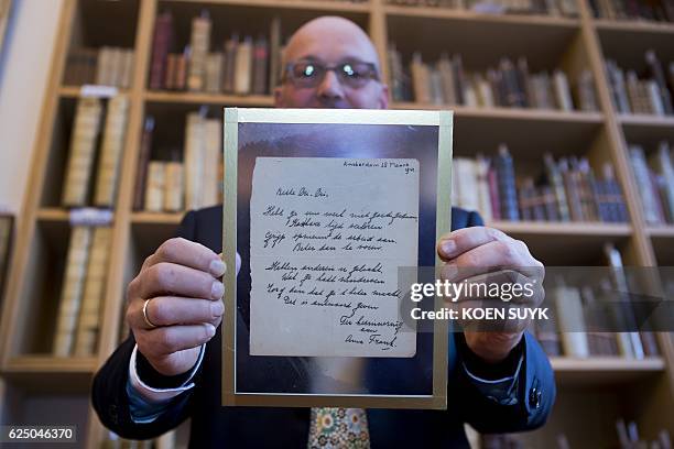 Man shows a handwritten poem by Anne Frank, written shortly before she went into hiding from the Nazis, at the auction Bubb Kuyper in Haarlem on...