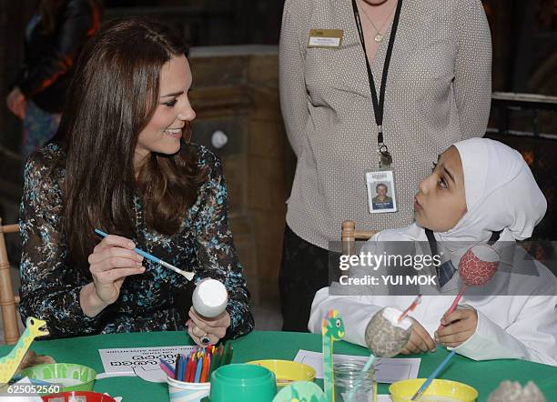 Britain's Catherine, Duchess of Cambridge, makes a dinosaur egg with pupils from Oakington Manor Primary School, at the Natural History Museum in...