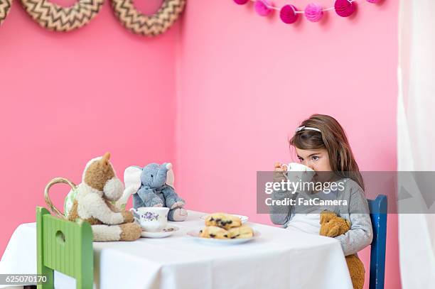 young girl having a tea party with her stuffed animals - cute arab girls stockfoto's en -beelden