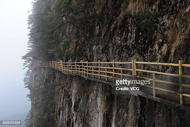 Tourists walk on the 1500-meter-high Qingyun Plank Road along the cliff of Mingyue Mountain on November 19, 2016 in Yichun, Jiangxi Province of...