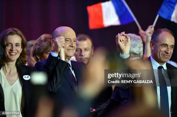 Alain Juppe , mayor of Bordeaux and candidate for the French right-wing presidential primary ahead of the 2017 presidential election, holds up the...