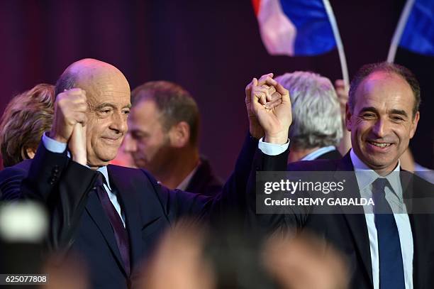 Alain Juppe , mayor of Bordeaux and candidate for the French right-wing presidential primary ahead of the 2017 presidential election, holds up the...