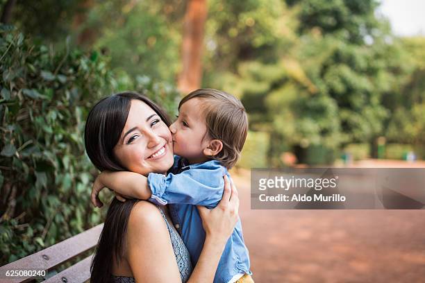 niño lindo besando a la madre en la mejilla - day 3 fotografías e imágenes de stock