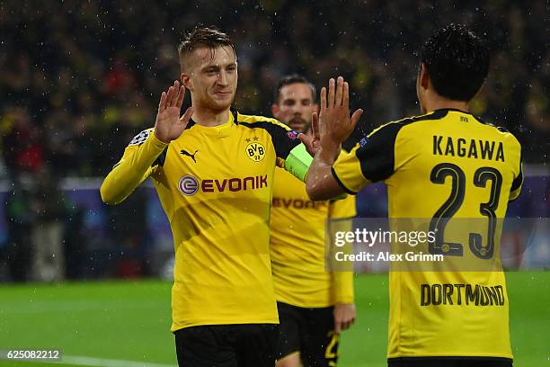 Marco Reus of Borussia Dortmund celebrates scoring his teams fifth goal with teammate Shinji Kagawa during the UEFA Champions League Group F match...