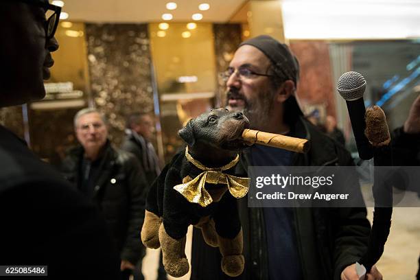 Robert Smigel and 'Triumph the Insult Comic Dog' walk through the lobby as they record video on 'Facebook Live' at Trump Tower, November 22, 2016 in...