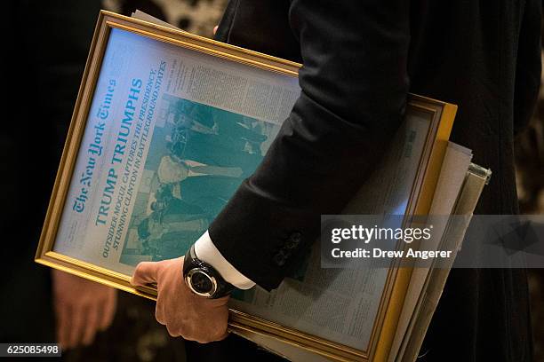 Staff member with the transition team carries a printing press plate of the November 9th edition of The New York Times at Trump Tower, November 22,...