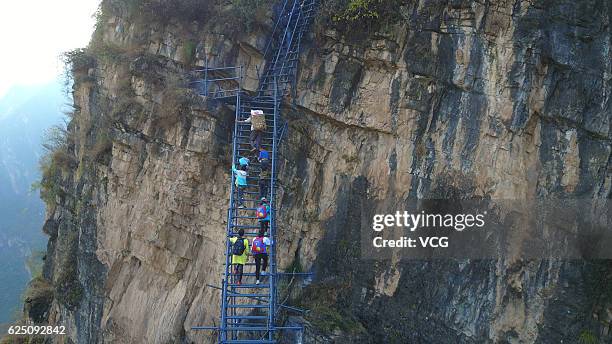 Children climb the steel ladder on the cliff on November 19, 2016 in Liangshan Yi Autonomous Prefecture, Sichuan Province of China. A new steel...