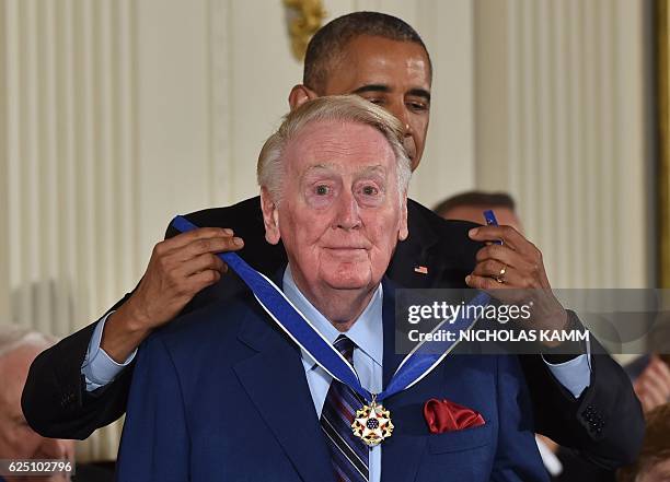 President Barack Obama presents sports broadcaster Vin Scully with the Presidential Medal of Freedom, the nation's highest civilian honor, during a...