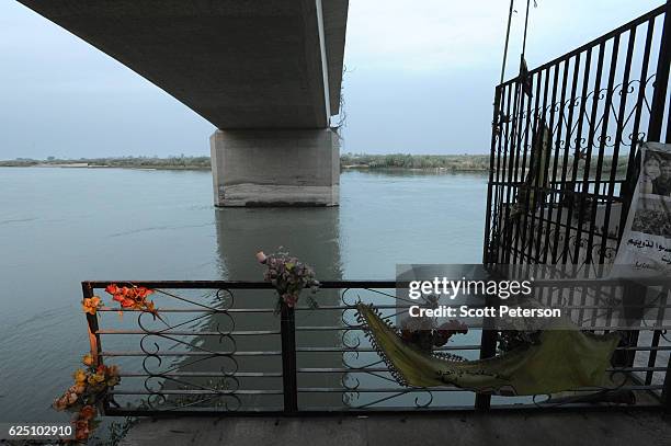 Darkness gathers over the memorial to the Islamic State massacre of 1,700 Shiite Air Force cadets from Camp Speicher beneath a bridge where victims...