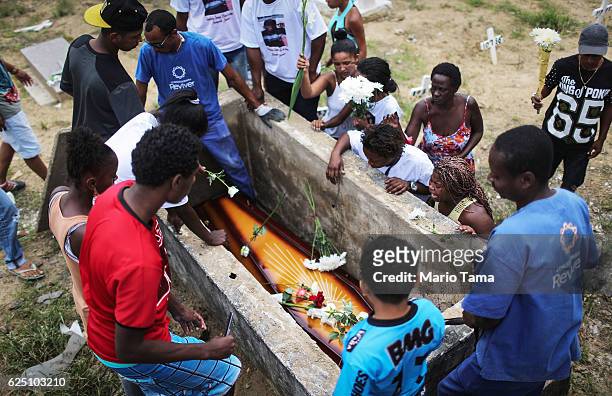 Mourners gather around the casket during the burial of Leonardo Martins da Silva Junior who was killed during a weekend police operation in the...