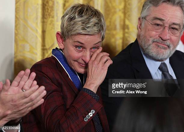 Comedian and talk show host Ellen DeGeneres wipes tears as actor Robert De Niro looks on during a Presidential Medal of Freedom presentation ceremony...