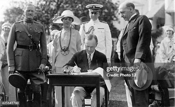 John Calvin Coolidge, 30th President of the USA 1923-1929, signing bills on the White House Lawn. General of the Armies John Joseph Pershing looks on.