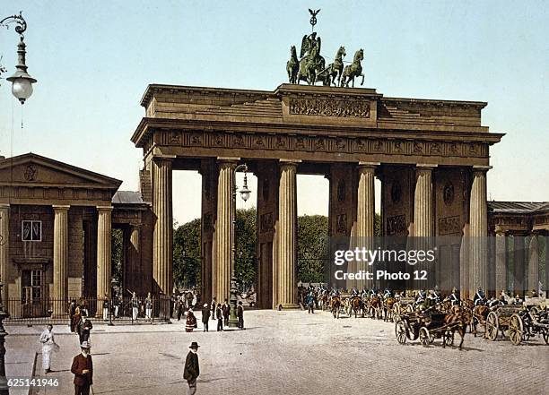 The Brandenburg Gate, Berlin. Carriages with mounted military escort passing through central arch into Unter den Linden.