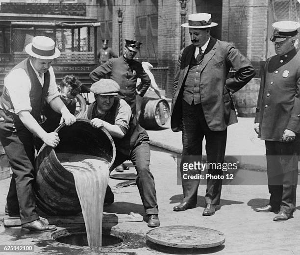 Prohibition in the USA 1920-1933: A barrel of confiscated illegal beer being poured down a drain.