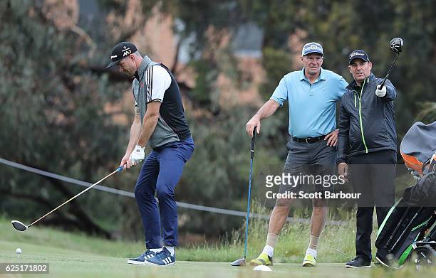 Kevin Pietersen tees off as former cricketer Shane Warne and former AFL player Sam Newman look on on Pro-Am Day ahead of the World Cup of Golf at...