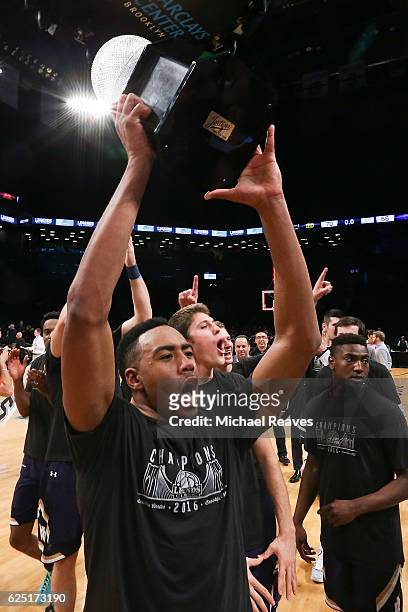 Bonzie Colson of the Notre Dame Fighting Irish raises the trophy for the fans after they defeated the Northwestern Wildcats 70-66 in the championship...